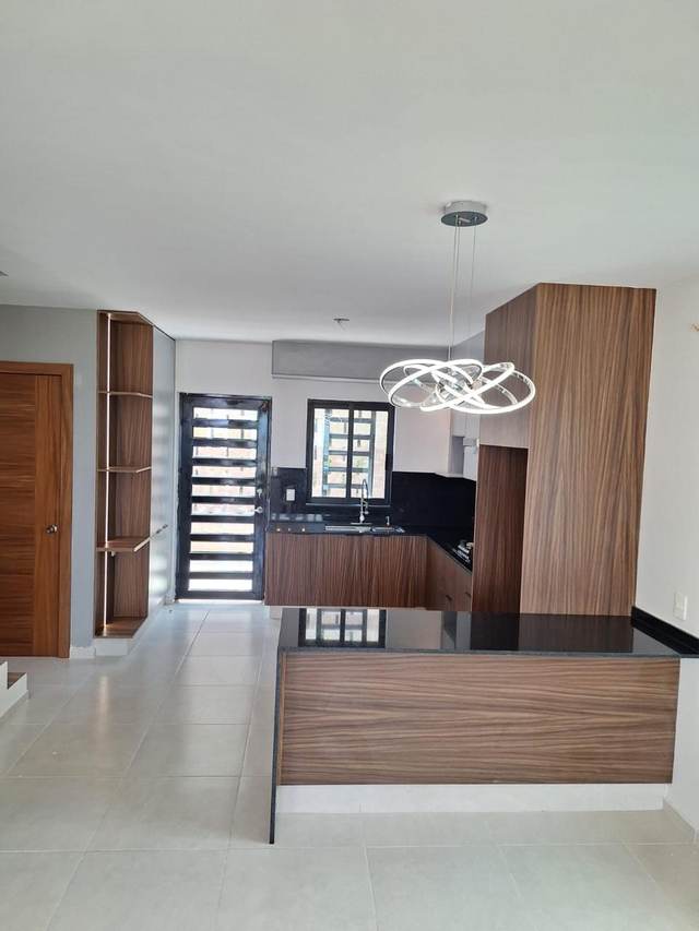Cocina de concepto abierto en madera con isla y lámpara colgante